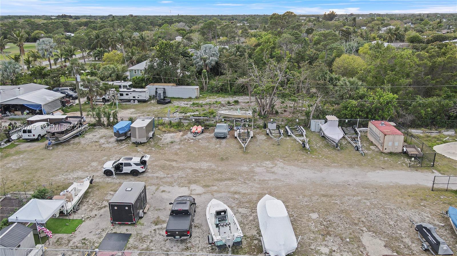 5313 Southeast Miles Grant Road, Unit 206 Stuart, FL 34997 - Photo 37 of 39 a view of a backyard with table and chairs couches under an umbrella