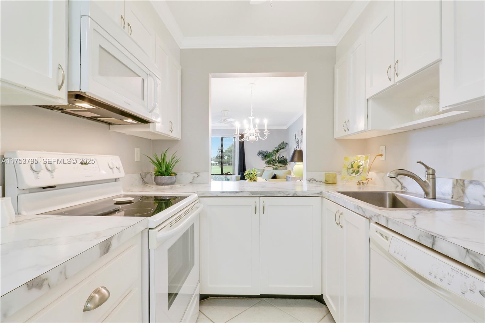 5313 Southeast Miles Grant Road, Unit 206 Stuart, FL 34997 - Photo 6 of 39 a kitchen with white cabinets and white appliances