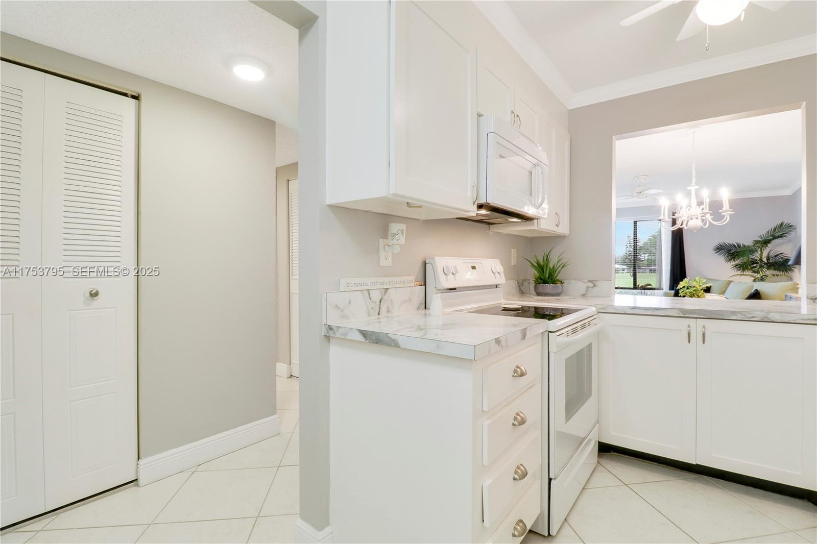 5313 Southeast Miles Grant Road, Unit 206 Stuart, FL 34997 - Photo 7 of 39 a kitchen with white cabinets and white appliances