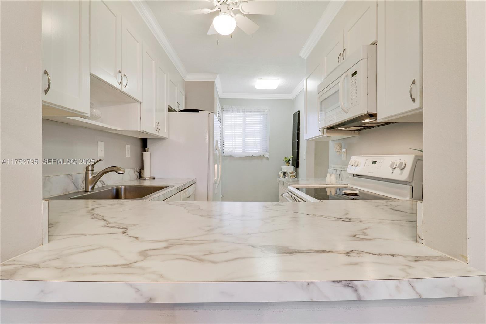5313 Southeast Miles Grant Road, Unit 206 Stuart, FL 34997 - Photo 9 of 39 a large white kitchen with stainless steel appliances