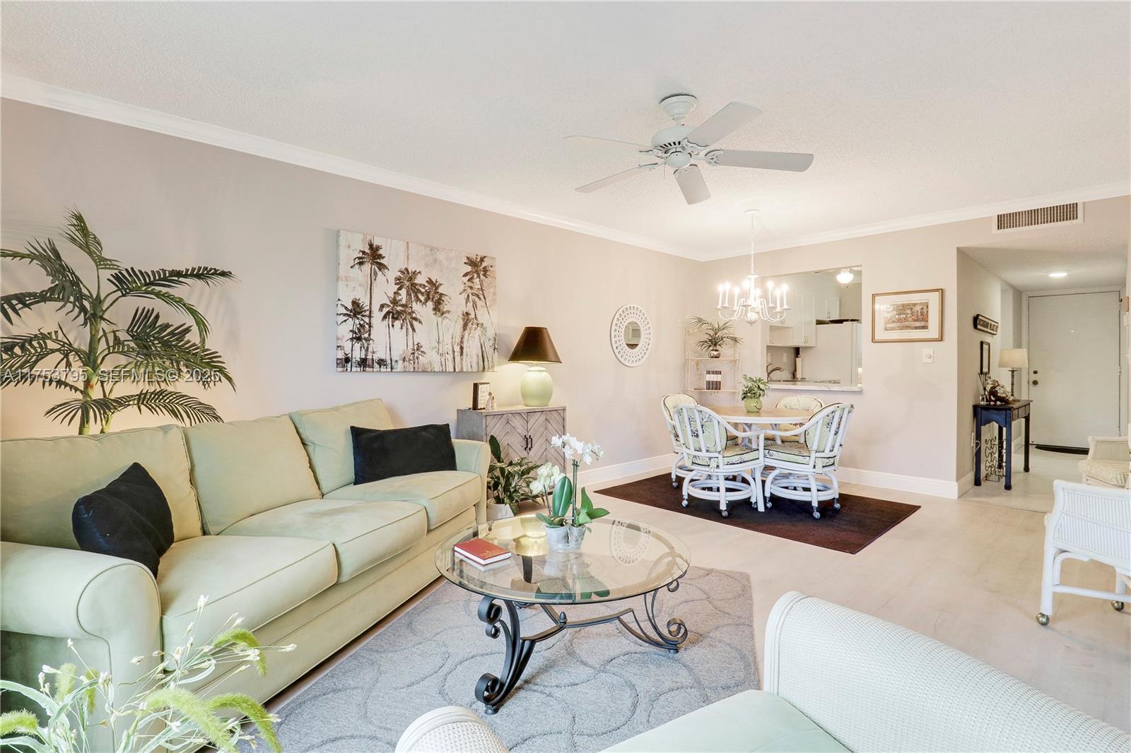 5313 Southeast Miles Grant Road, Unit 206 Stuart, FL 34997 - Photo 10 of 39 a living room with furniture and a chandelier