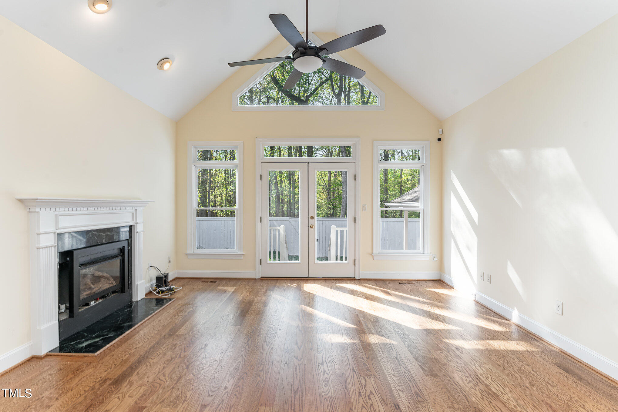 209 Stable Road Carrboro, NC 27510 - Photo 7 of 33 an empty room with windows fireplace and wooden floor