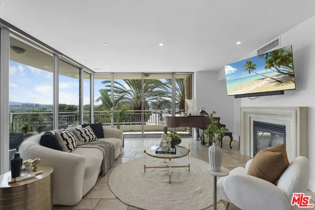 a living room with furniture fireplace and floor to ceiling windows