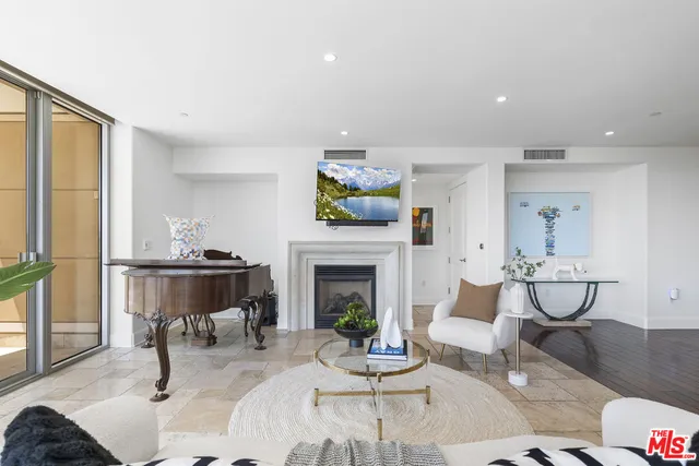 a living room with furniture a fireplace and a large window