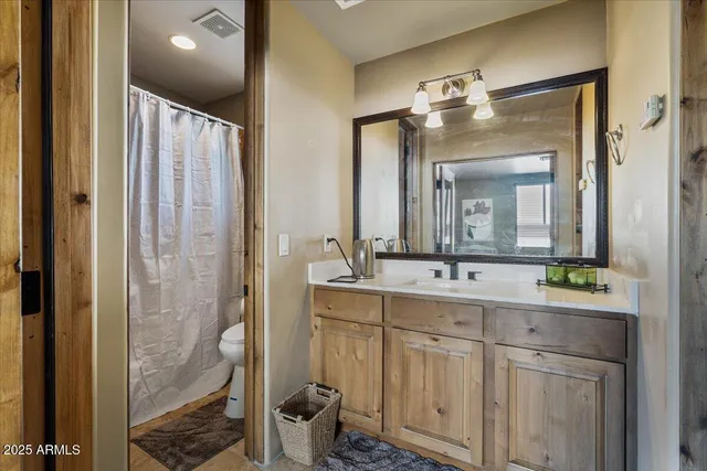 a living room with furniture a wooden floor and kitchen view