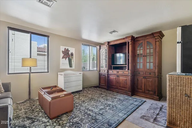 a living room with furniture a flat screen tv and a floor to ceiling window