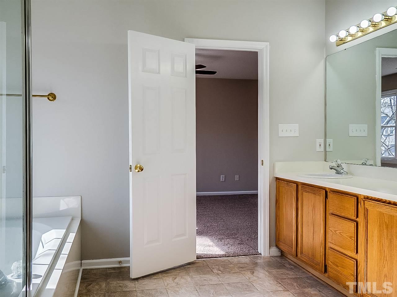 2500 Holbrook Court Raleigh, NC 27604 - Photo 15 of 26 a bathroom with a tub sink and mirror