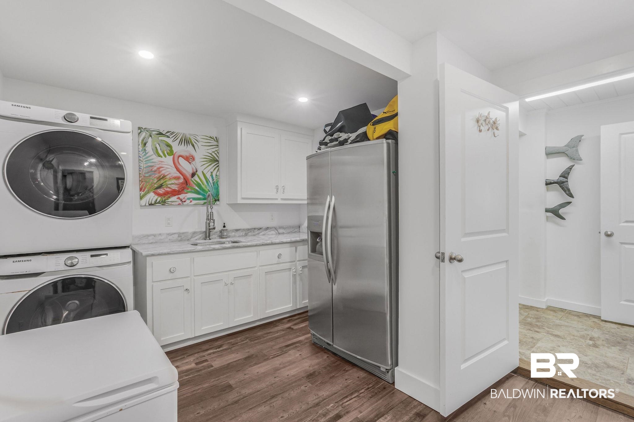 32130 River Road Orange Beach, AL 36561 - Photo 27 of 51 Washroom featuring dark wood-type flooring, stacked washing machine and dryer, and recessed lighting
