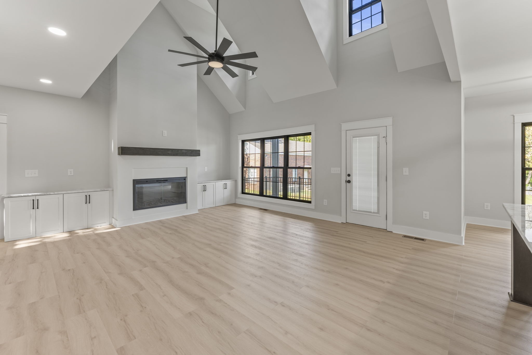 a view of empty room with wooden floor and fireplace