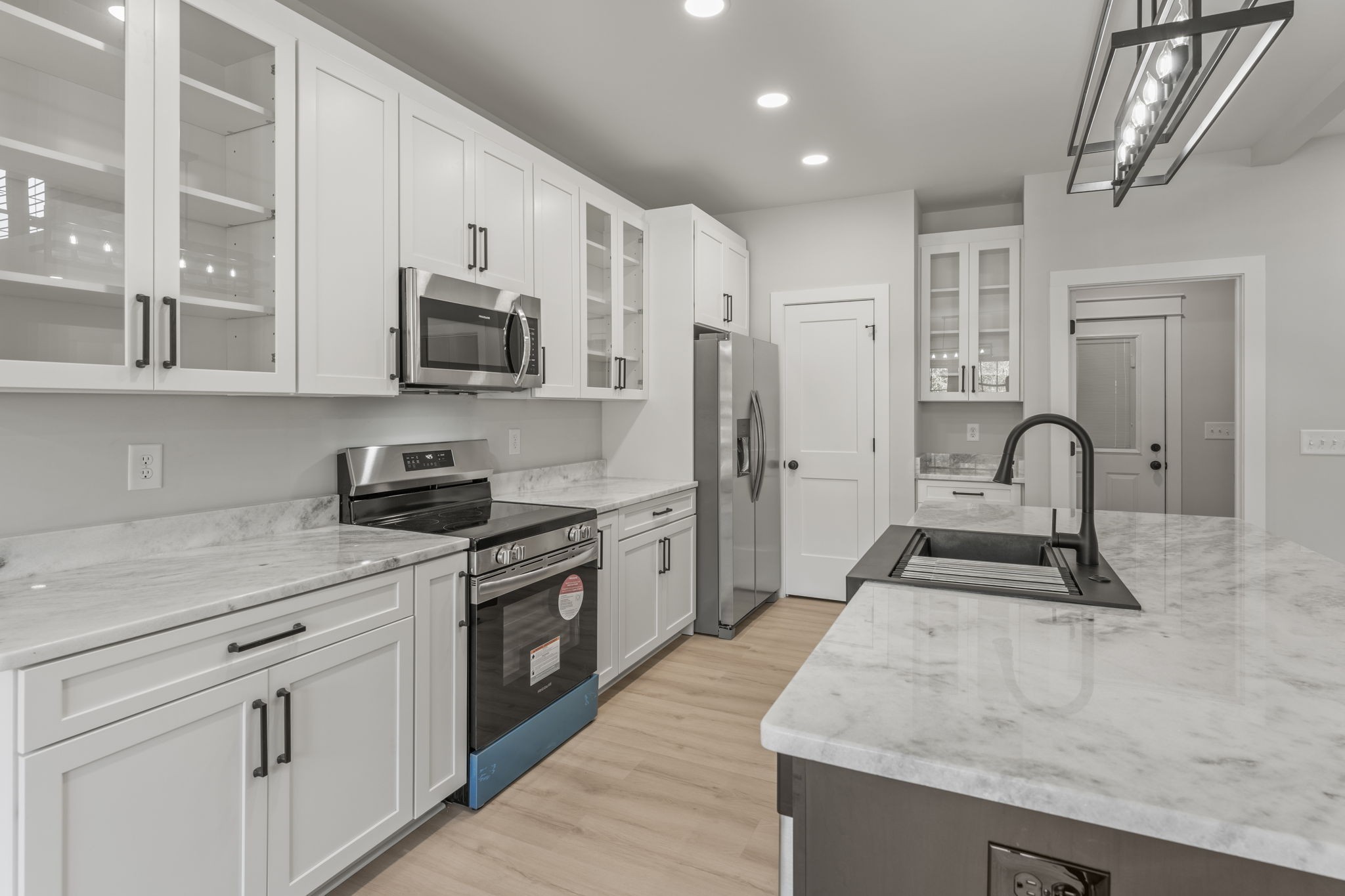 106 5th Avenue North Decherd, TN 37324 - Photo 12 of 50 a kitchen with stainless steel appliances granite countertop a stove top oven a sink a refrigerator and white cabinets