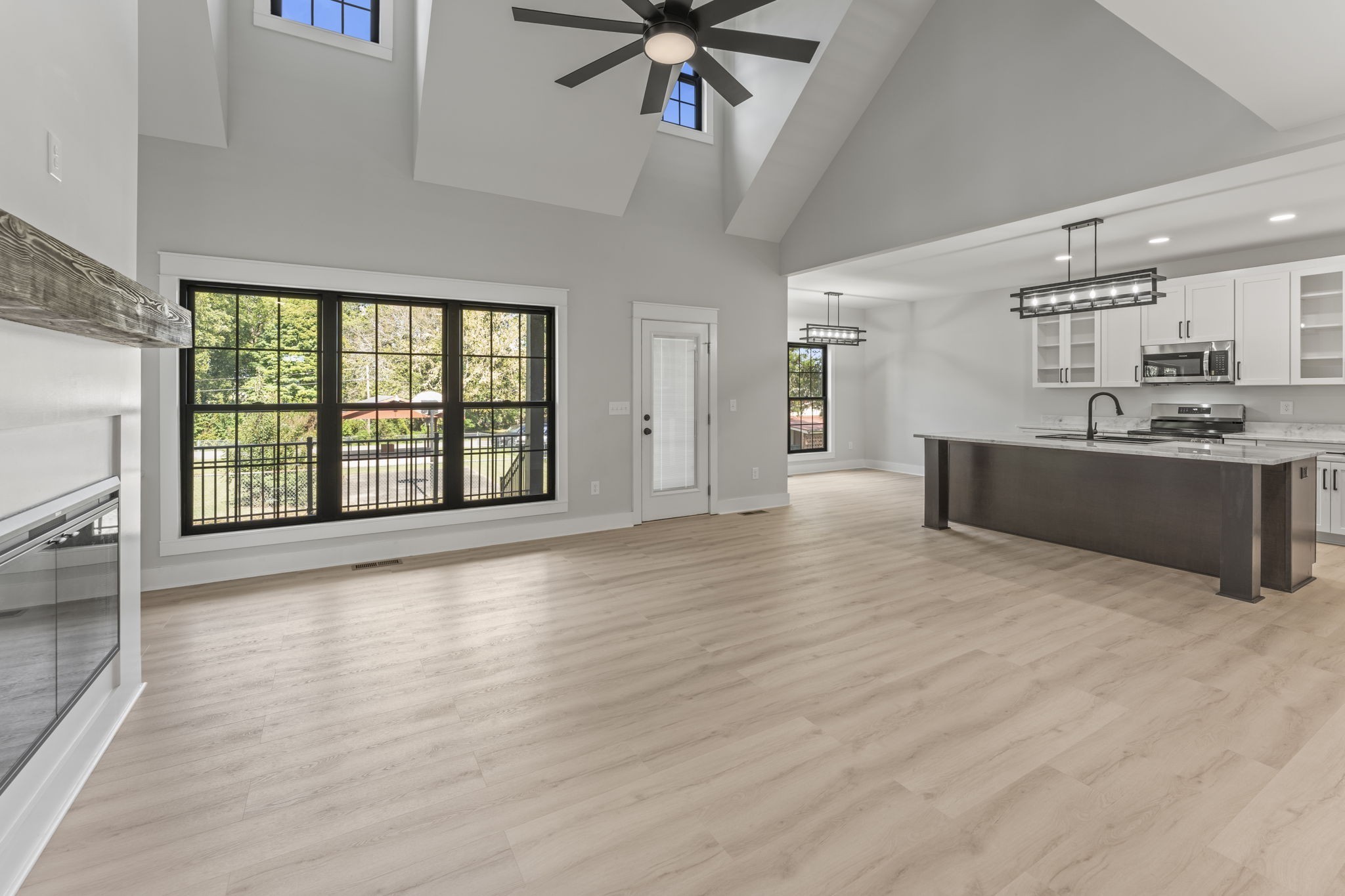 106 5th Avenue North Decherd, TN 37324 - Photo 9 of 50 an empty room with wooden floor and a kitchen