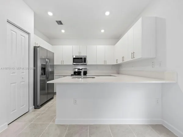 a kitchen with stainless steel appliances a refrigerator sink and microwave