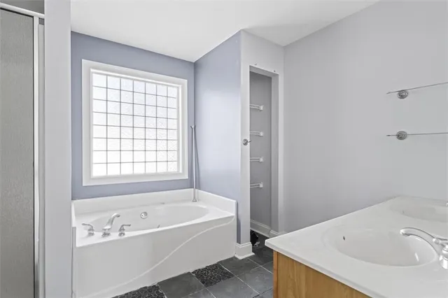 a bathroom with a tub a sink and a window