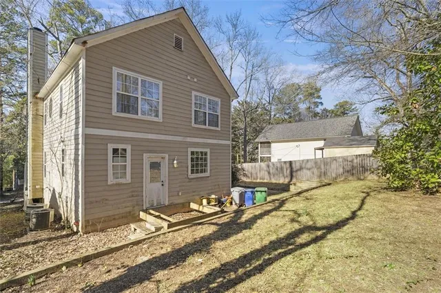 a view of a house with a yard and large tree