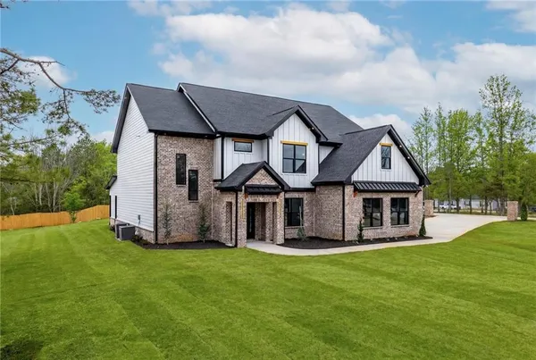 a front view of a house with a garden and yard