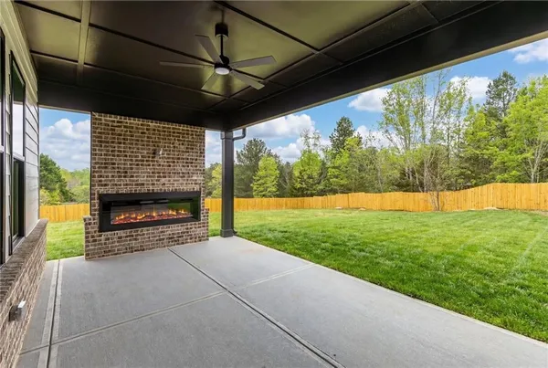 a view of an empty room with a fireplace and a window