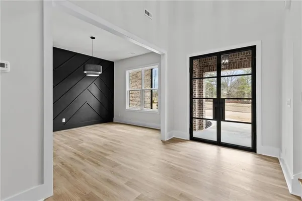 a view of an empty room with a window and wooden floor