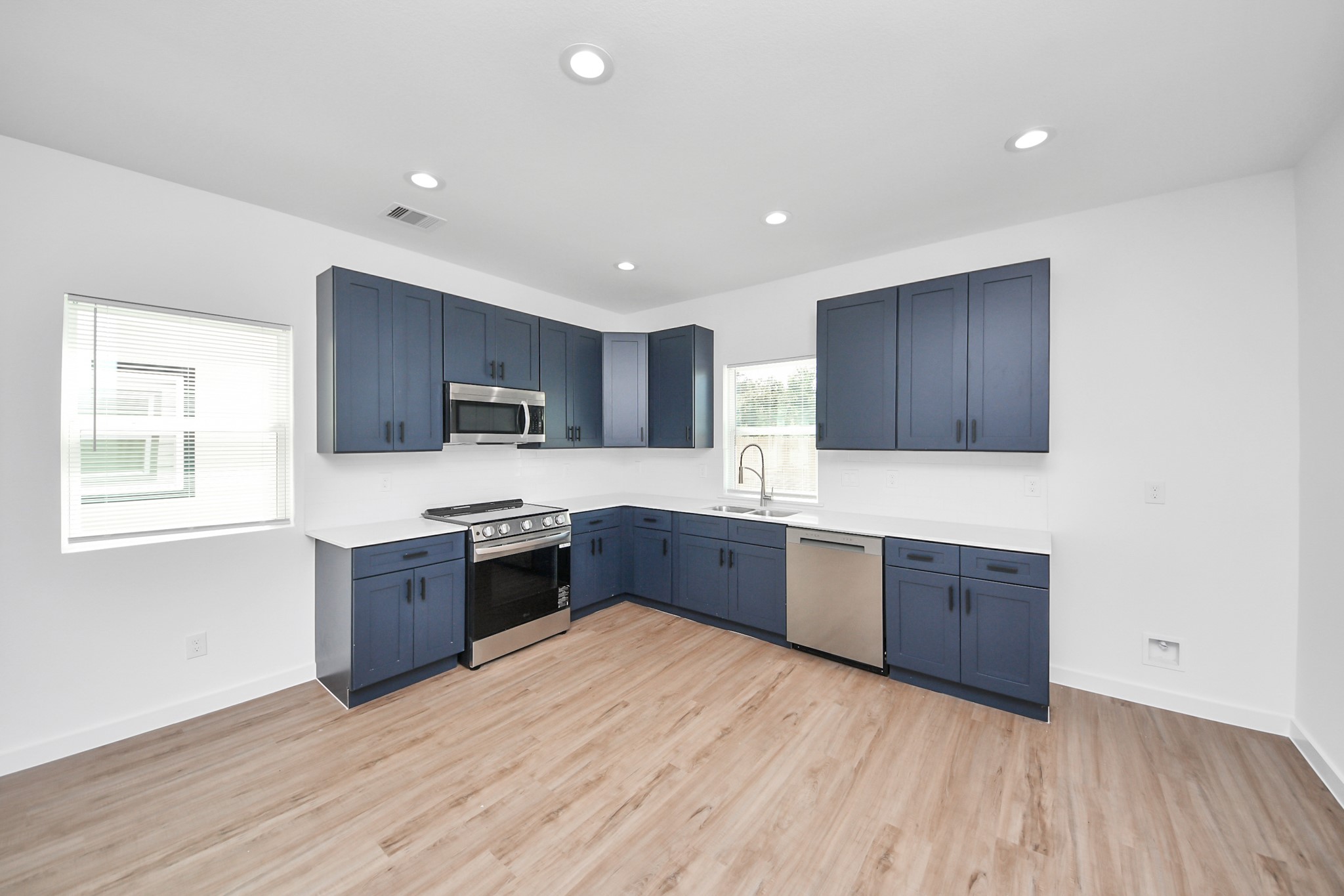 7312 Wileyvale Road, Unit C Houston, TX 77016 - Photo 13 of 39 a large kitchen with wooden floors and stainless steel appliances