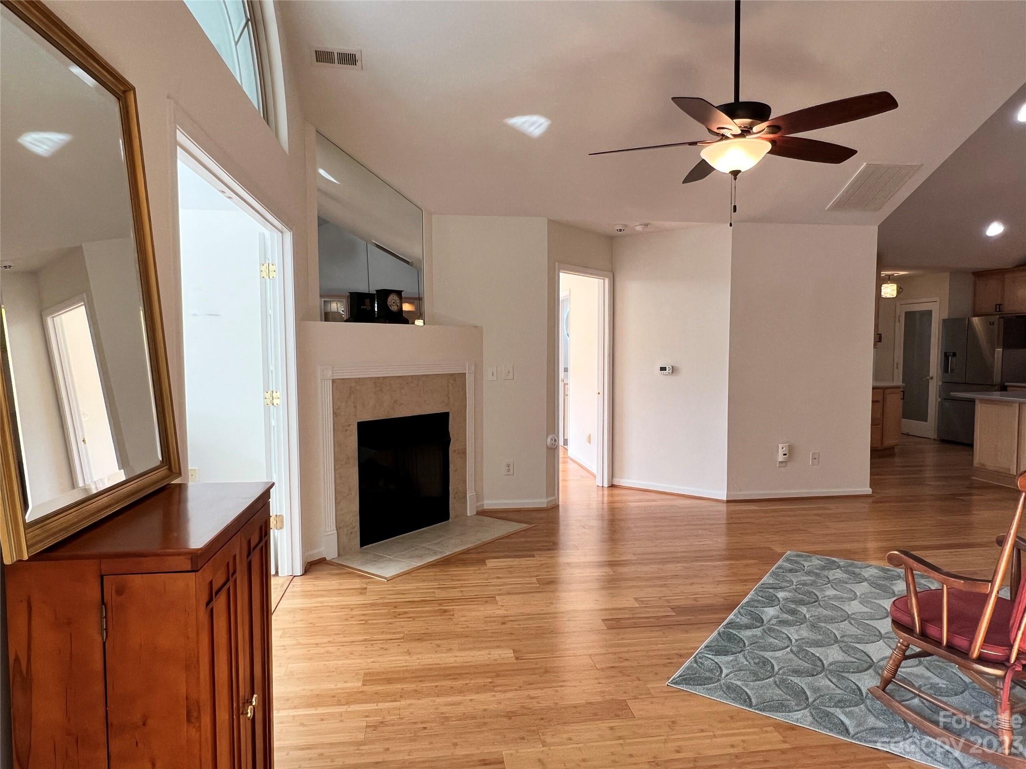 721 Ledgestone Court Tega Cay, SC 29708 - Photo 6 of 35 a view of a livingroom with a ceiling fan a fireplace a ceiling fan and wooden floor
