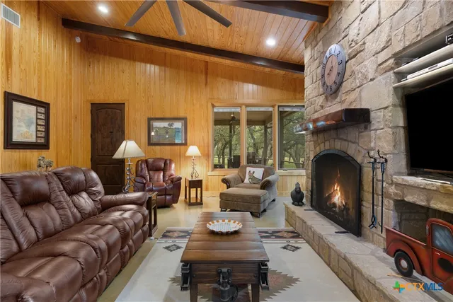 a living room with furniture a fireplace and a flat screen tv