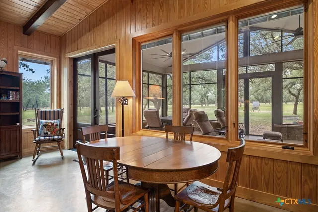 a dining room with furniture a chandelier and wooden floor
