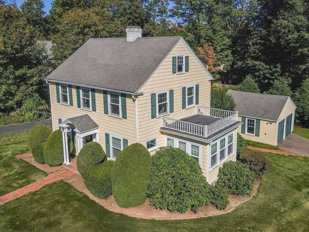 a aerial view of a house with yard and trees