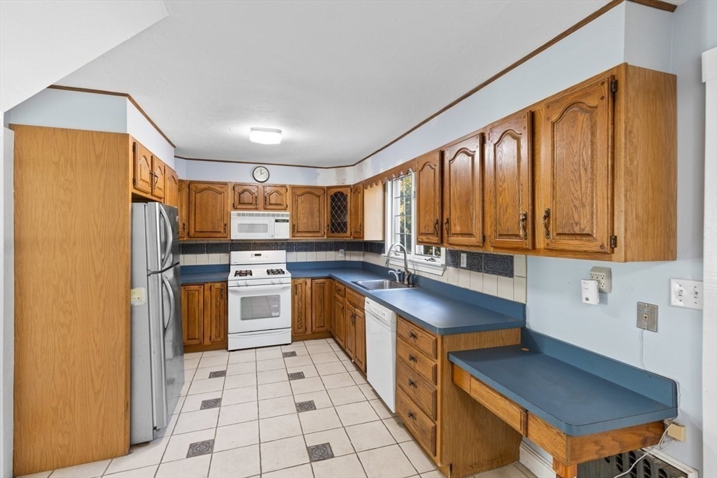 14 Cottage Street Sharon, MA 02067 - Photo 12 of 27 a kitchen with stainless steel appliances granite countertop a sink a stove a refrigerator cabinets and a dining table