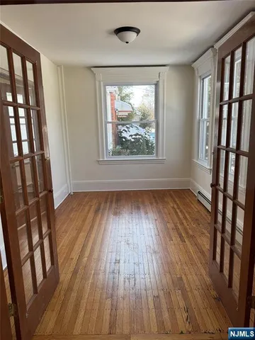 a view of an empty room with wooden floor and staircase