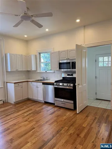 a kitchen with stainless steel appliances kitchen island granite countertop a stove a refrigerator and a sink
