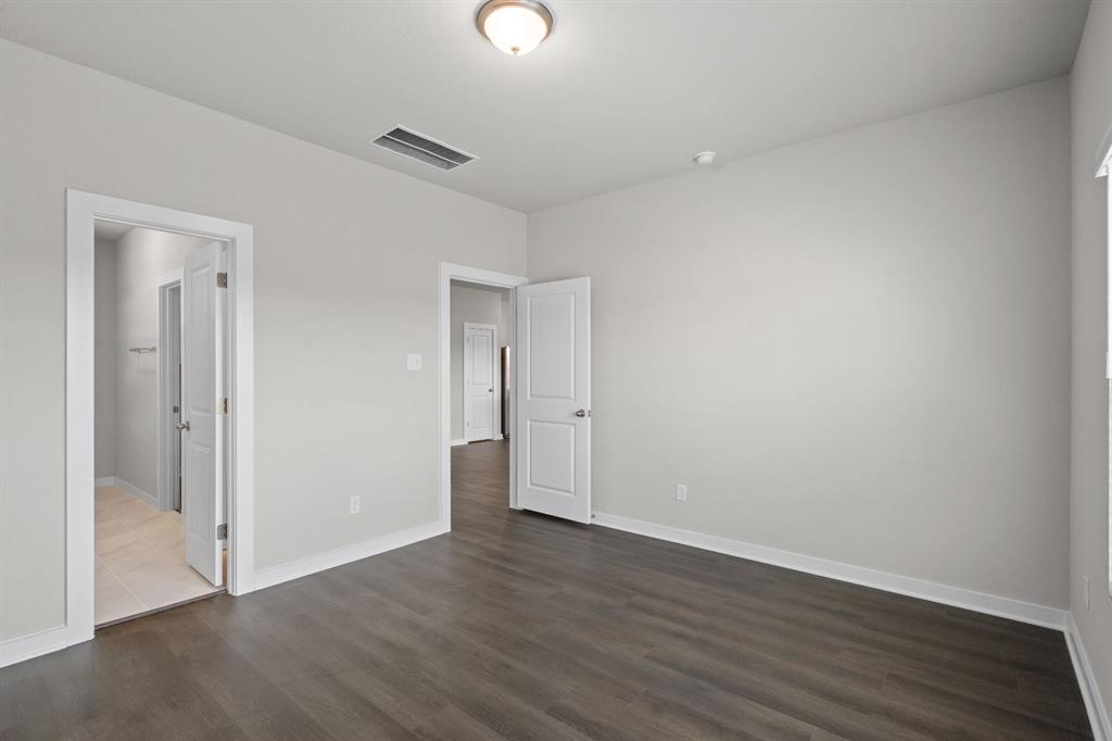 177 Sleep Hollow Jarrell, TX 76537 - Photo 15 of 24 Spacious room featuring wood-finish flooring, light neutral wall paint, white trim, and a ceiling-mounted light fixture