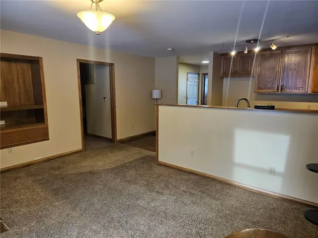 a view of an empty room with a kitchen