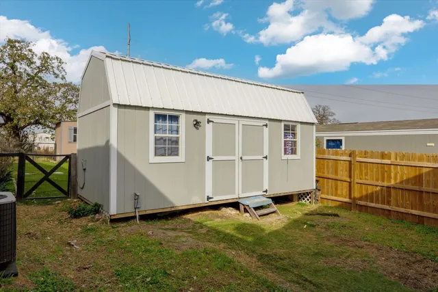 a view of a house with backyard and a tree