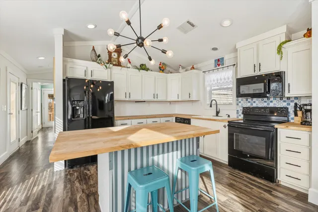 a kitchen with a refrigerator a stove top oven a sink dishwasher and a fireplace