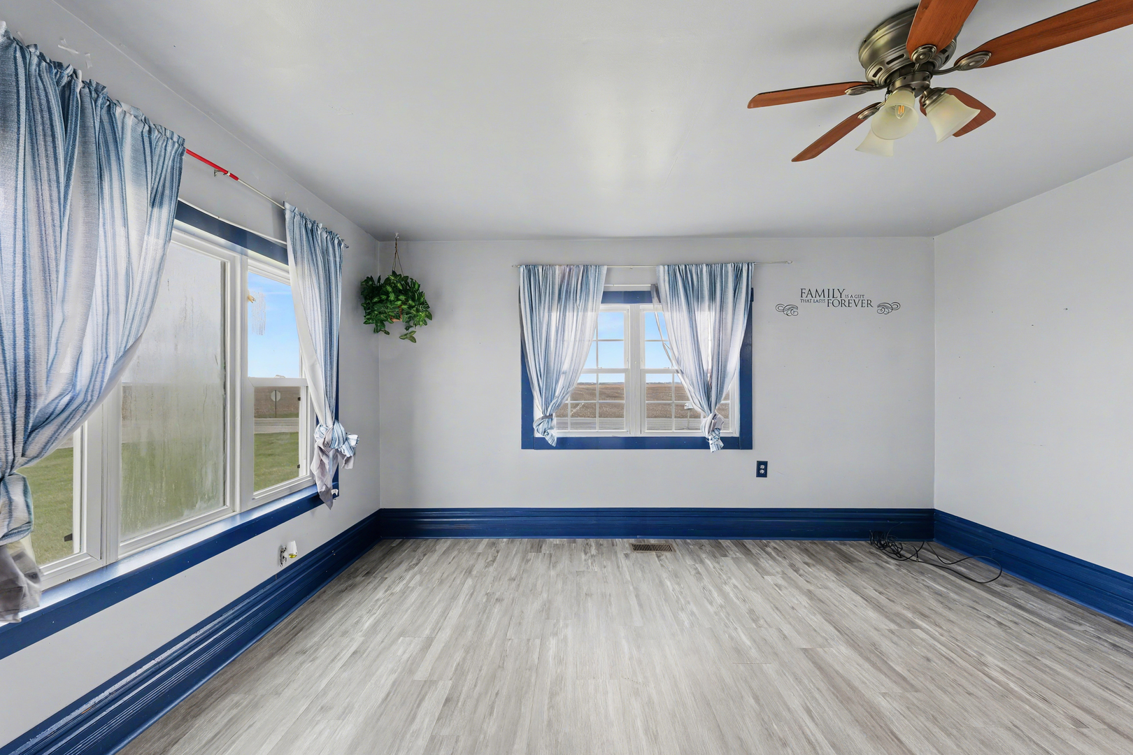 724 East 2600 North Road Penfield, IL 61862 - Photo 23 of 43 a view of an empty room with a window and wooden floor