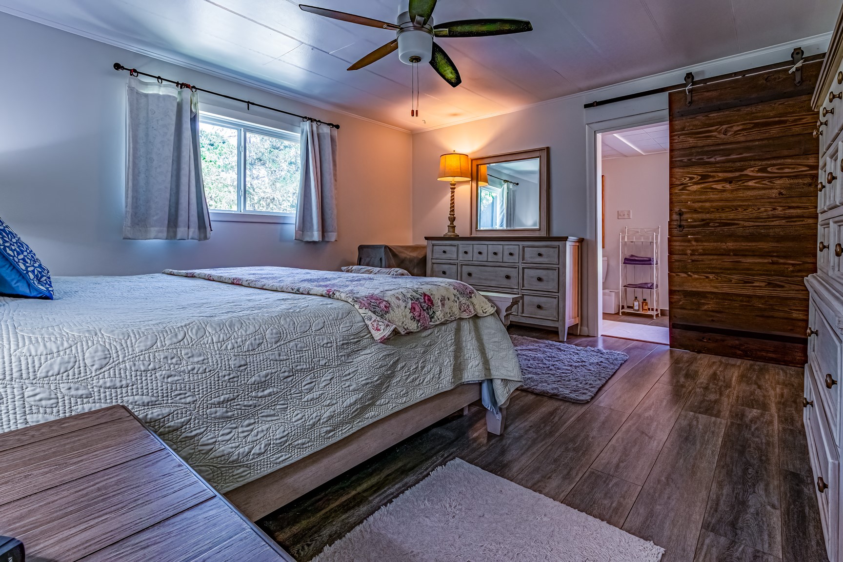 480 Johnson Road Coldspring, TX 77331 - Photo 37 of 49 Primary bedroom boasts an ensuite bath with beautiful barn doors. Quite spacious to easily accommodate oversized furniture.