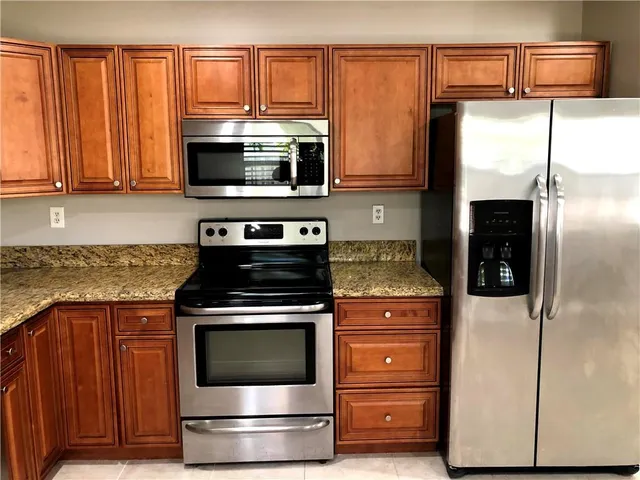 a kitchen with stainless steel appliances granite countertop a stove microwave and refrigerator