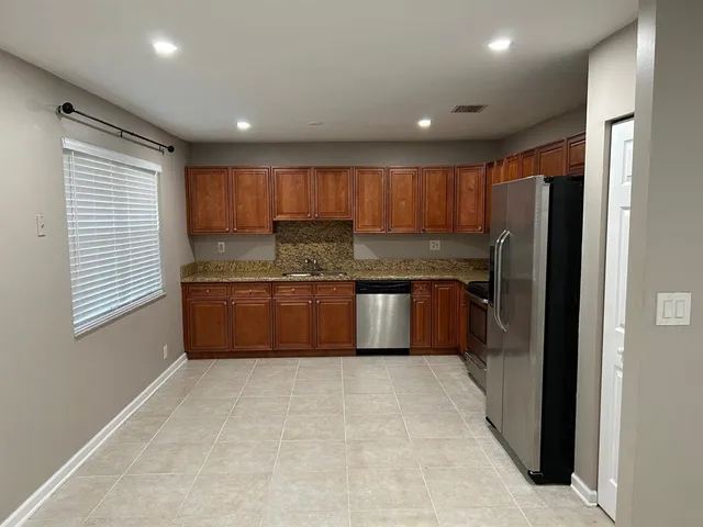 a kitchen with stainless steel appliances granite countertop a refrigerator and a sink