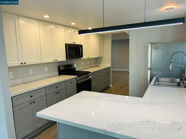 a view of an empty room with wooden floor and closet area