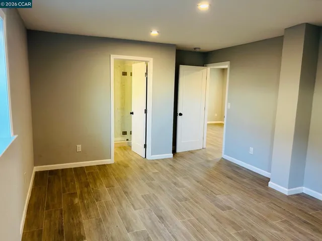 an empty room with wooden floor and closet