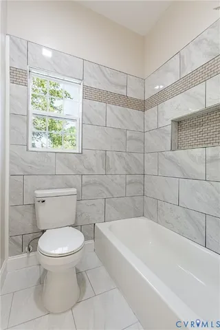 a white toilet and a bath tub sitting in a bathroom