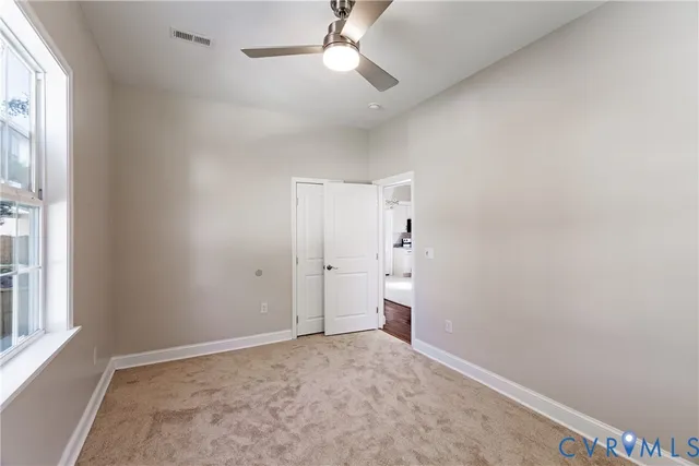 a view of empty room with ceiling fan