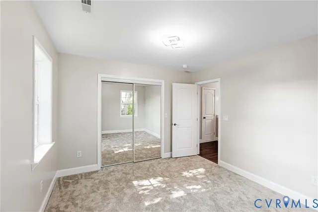 a view of a room with wooden floor fan and windows