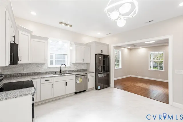 a kitchen with a sink stainless steel appliances and window