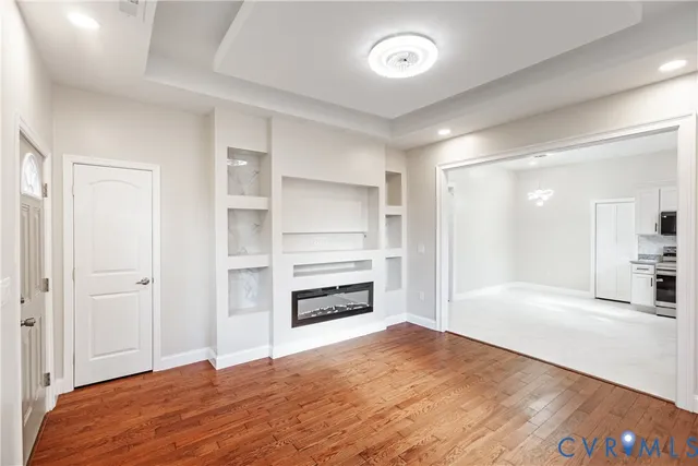 a view of empty room with a fireplace and wooden floor
