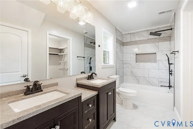 a bathroom with a sink toilet double vanity and shower
