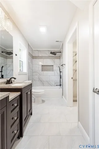 a bathroom with a granite countertop sink a toilet and shower