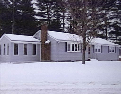 a front view of a house with a yard covered with snow