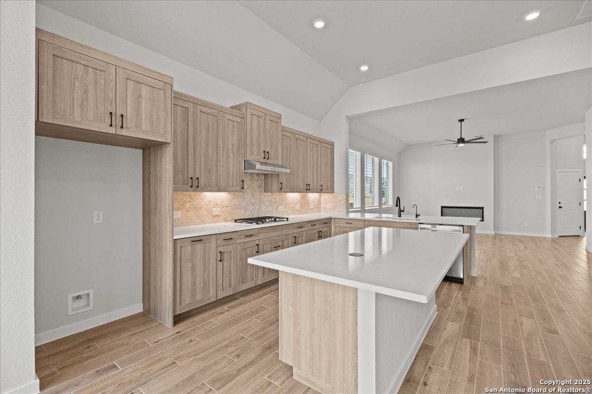 2122 Shepards Street Seguin, TX 78155 - Photo 15 of 28 a kitchen with kitchen island granite countertop a sink stove and wooden cabinets