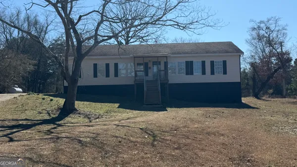 a front view of a house with a yard covered with snow