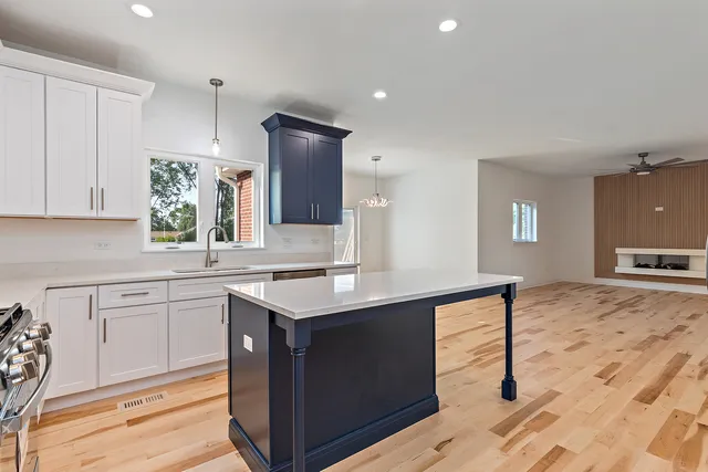 a kitchen with a sink cabinets and wooden floor